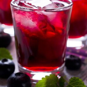 Glass of water with ice and blueberry drink syrup