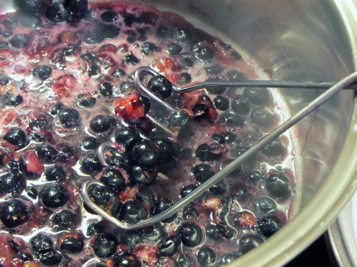Process shot of making a blueberry shrub syrup