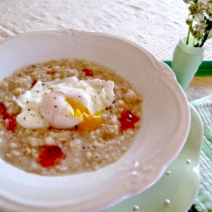 Oatmeal with dollops of raspberry hot pepper jelly and a poached egg in the middle