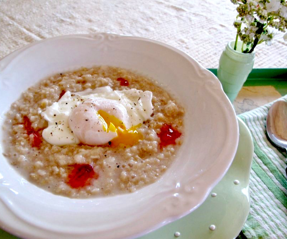 Oatmeal with dollops of raspberry hot pepper jelly and a poached egg in the middle