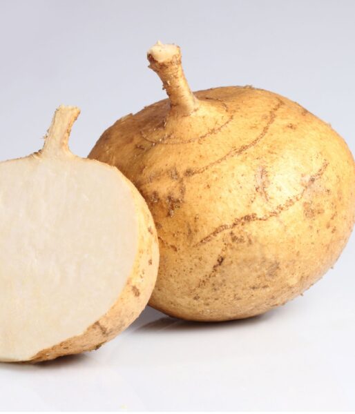 Jicama root, one that is whole and one that is cut in half showing the inside.