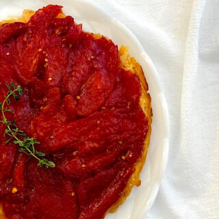 Tomato tartin after being flipped onto white plate