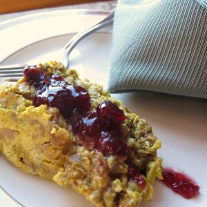 Slice of bobotie with cranberry chutney topping