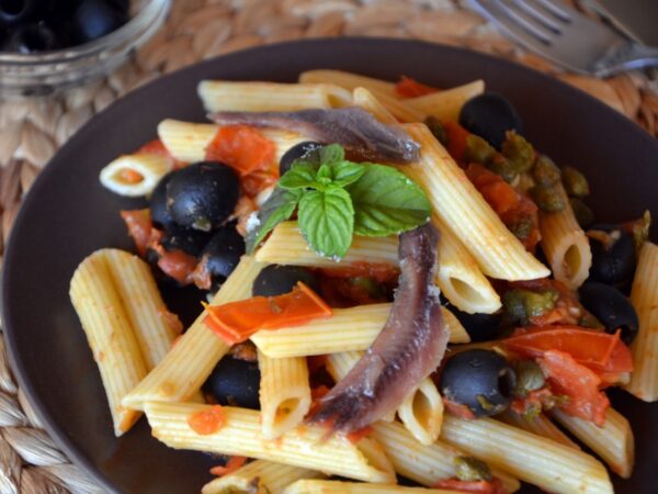 Italian puttanesca with pasta in a bowl served cold.