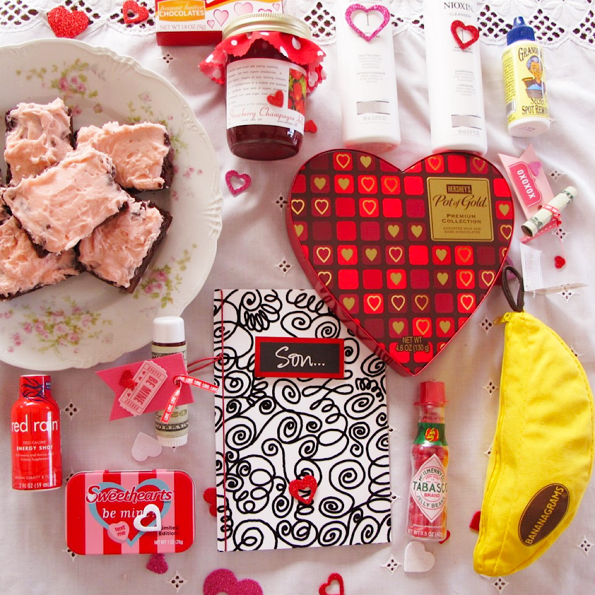 Items to go in a Valentines care package for a college boy, laid out on a white tablecloth.