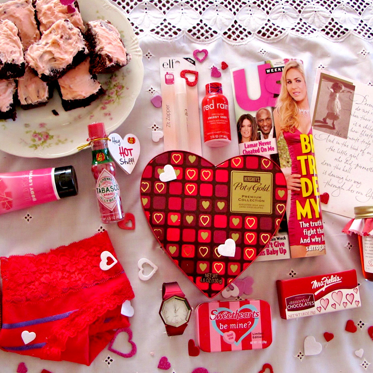 Items to go in a Valentines care package for a college girl, laid out on a white tablecloth.