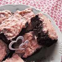 Plate of strawberry brownies with pink rosewater frosting