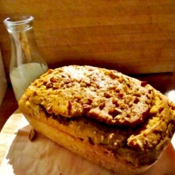 Pumpkin amaretto quick bread loaf with milk in background.