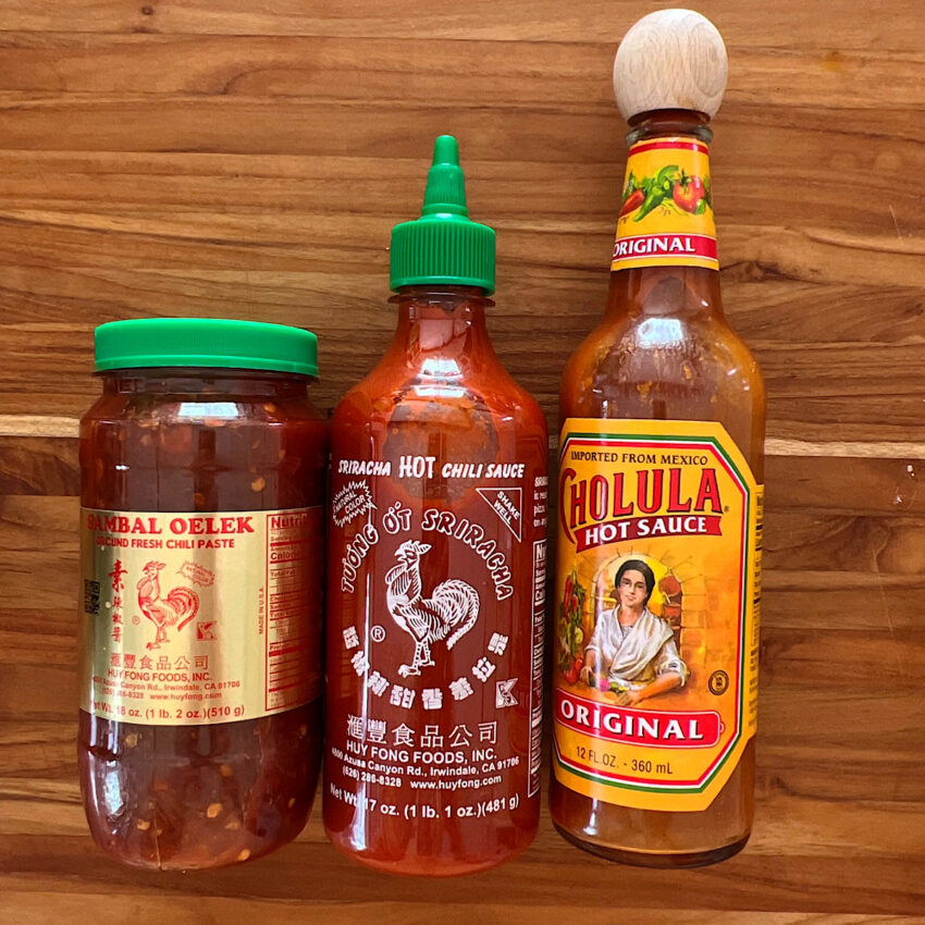 3 hot sauces that go well with pho: sambal, sriracha, and cholula.