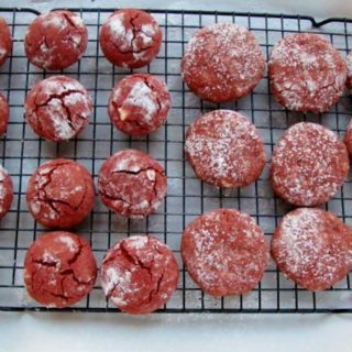 Red velvet crinkle cookies cooling on rack