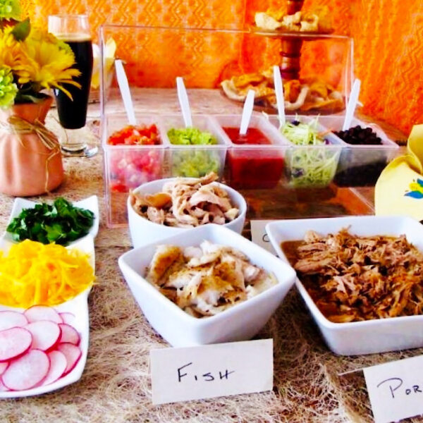 Taco bar options for fillings including meat, cheese, radish and sauces.