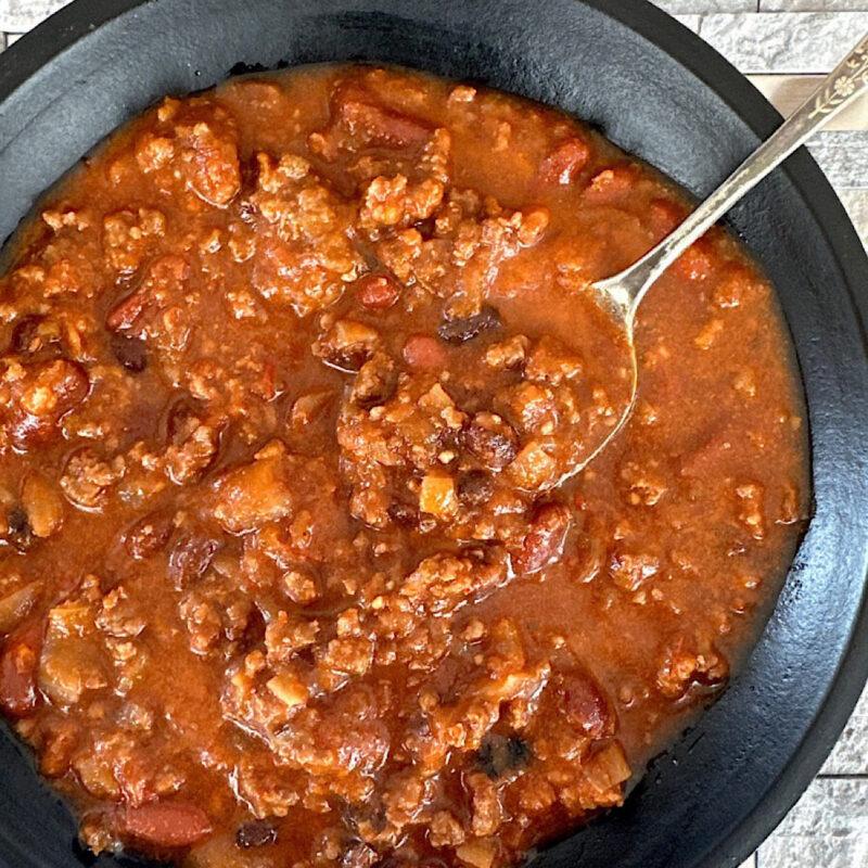 Slow carb beef and bean chili in a black bowl.