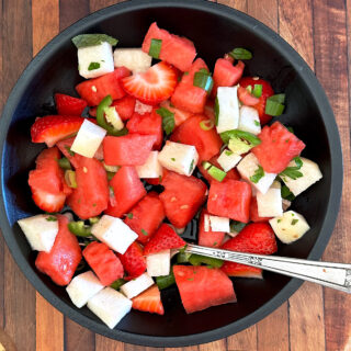 Watermelon jicama fruit salad in black bowl.