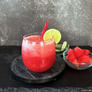 Watermelon aqua fresca in a glass with a lime wedge garnish.