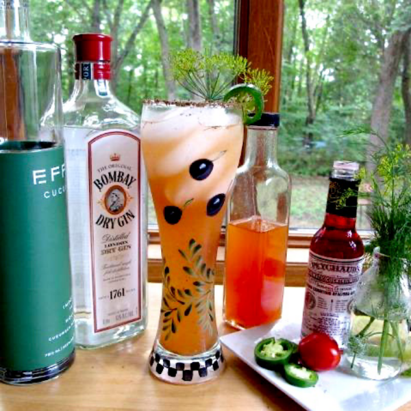 Bloody Mary with ingredients laid out on window table.