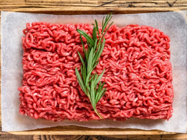 Ground beef with 20% fat and a sprig of rosemary on top.