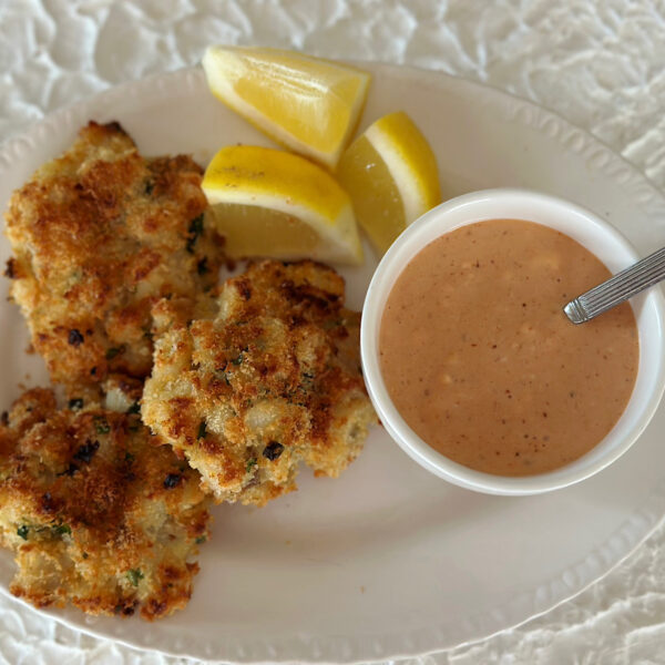 3 fish cakes with lemon garnish and a Southern comeback dipping sauce.
