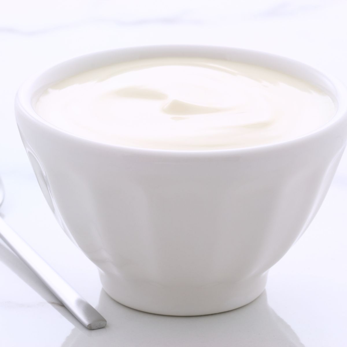 White bowl of plain Greek yogurt.