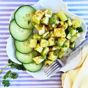 Cucumber avocado salad on a blue striped background