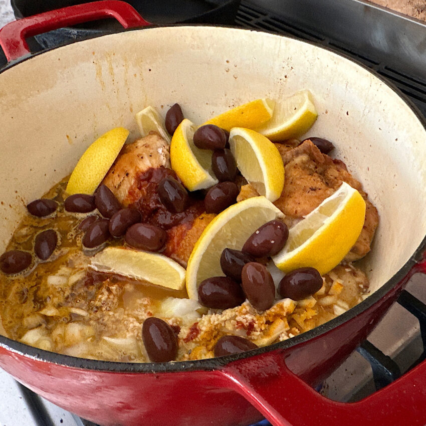 Dutch oven pot with all ingredients for Moroccan chicken stew.