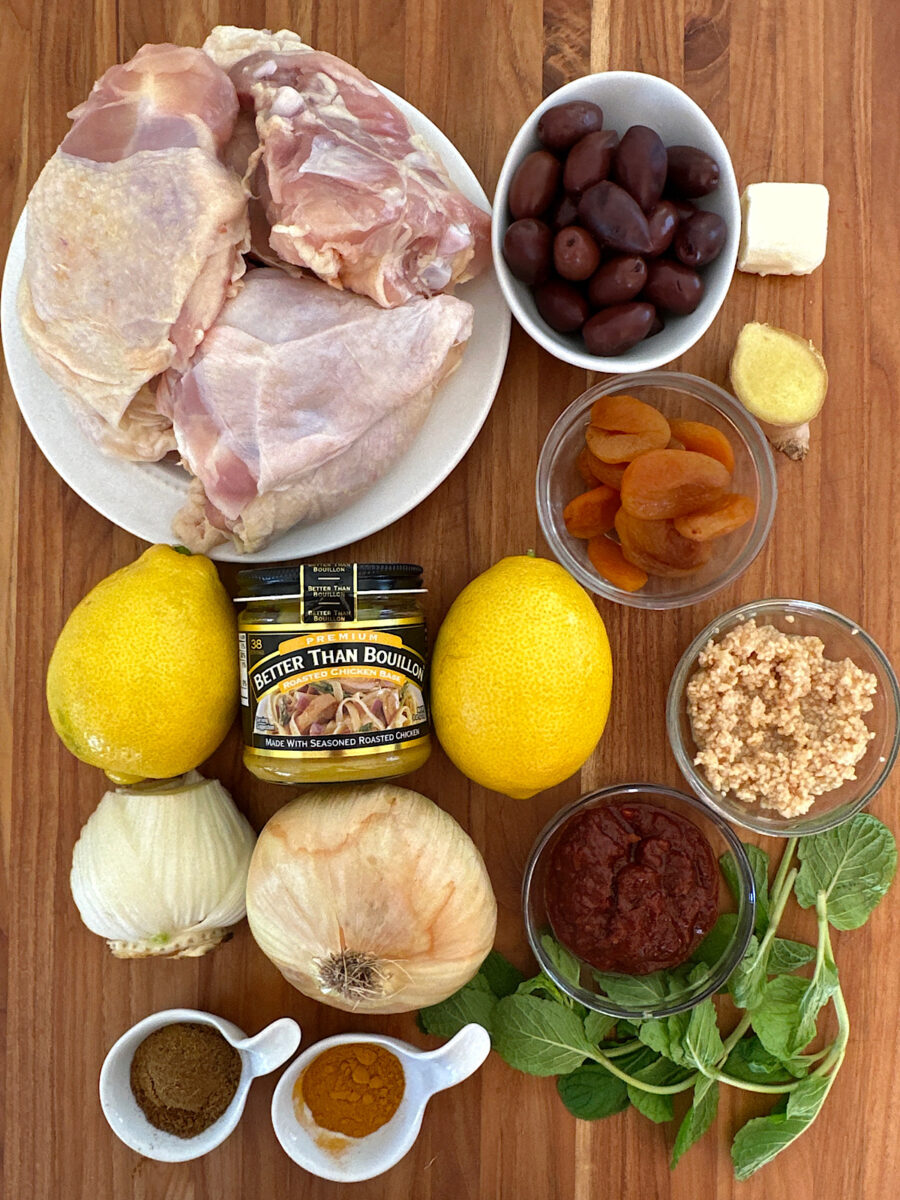 Ingredients for Moroccan chicken stew, including chicken, harissa, lemons, garlic, mint, fennel, and spices.