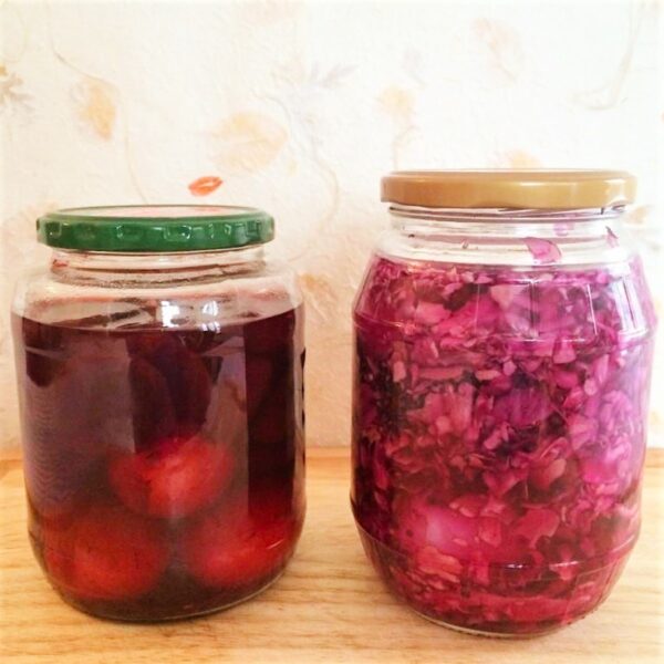 2 pickling jars with eggs; 1 with red cabbage and 1 with beets.