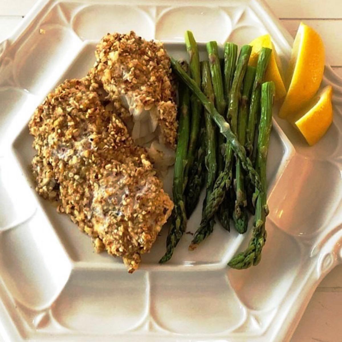 Low carb fish dinner of almond-crusted cod with asparagus spears