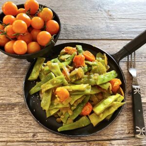 Romano beans with Sungold cherry tomatoes in skillet saute