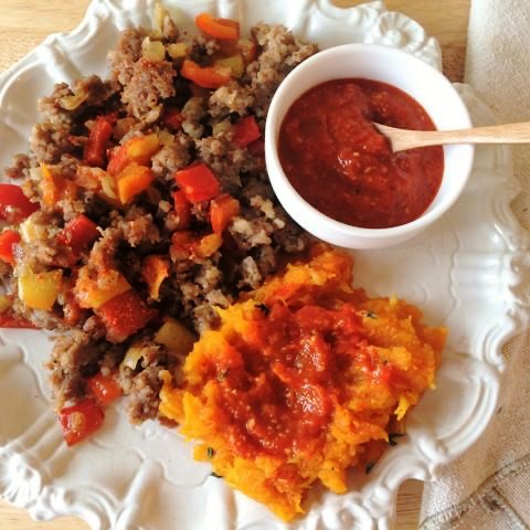 Ground beef sauteed with pepperonata and butternut squash topped with romesco sauce and bowl of romesco sauce on the side.