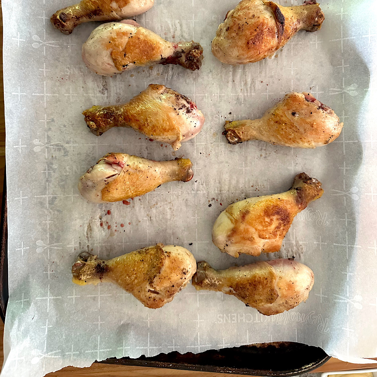 Chicken legs on baking sheet coated with mustard and low carb breading.