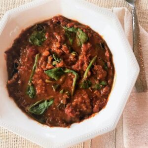 Bowl of lentil spinach soup with smoked tomatoes