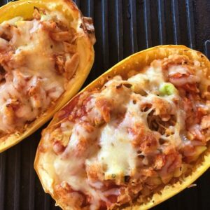 Low Carb spaghetti squash, chicken and enchilada sauce served in a spaghetti squash shell