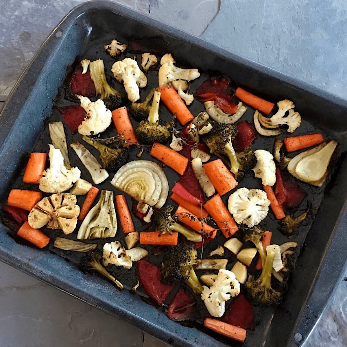 Sheet pan roasted vegetables drizzled with a fruit vinegar before roasting.