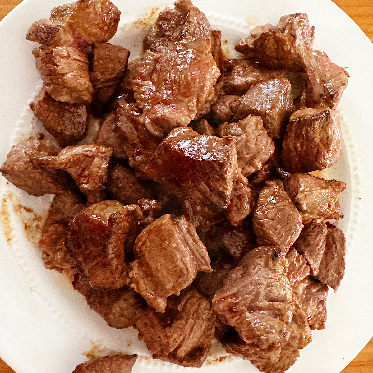 Seared chuck roast meat on a white plate.