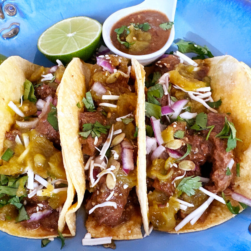 3 corn tortillas filled with pork chile verde, onions, cheese and cilantro.