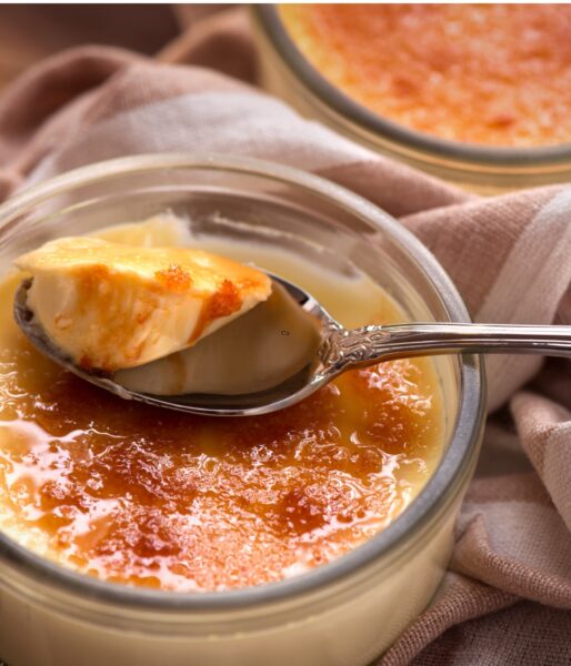 Creme  brûlée with a bite on a spoon showing the creamy texture