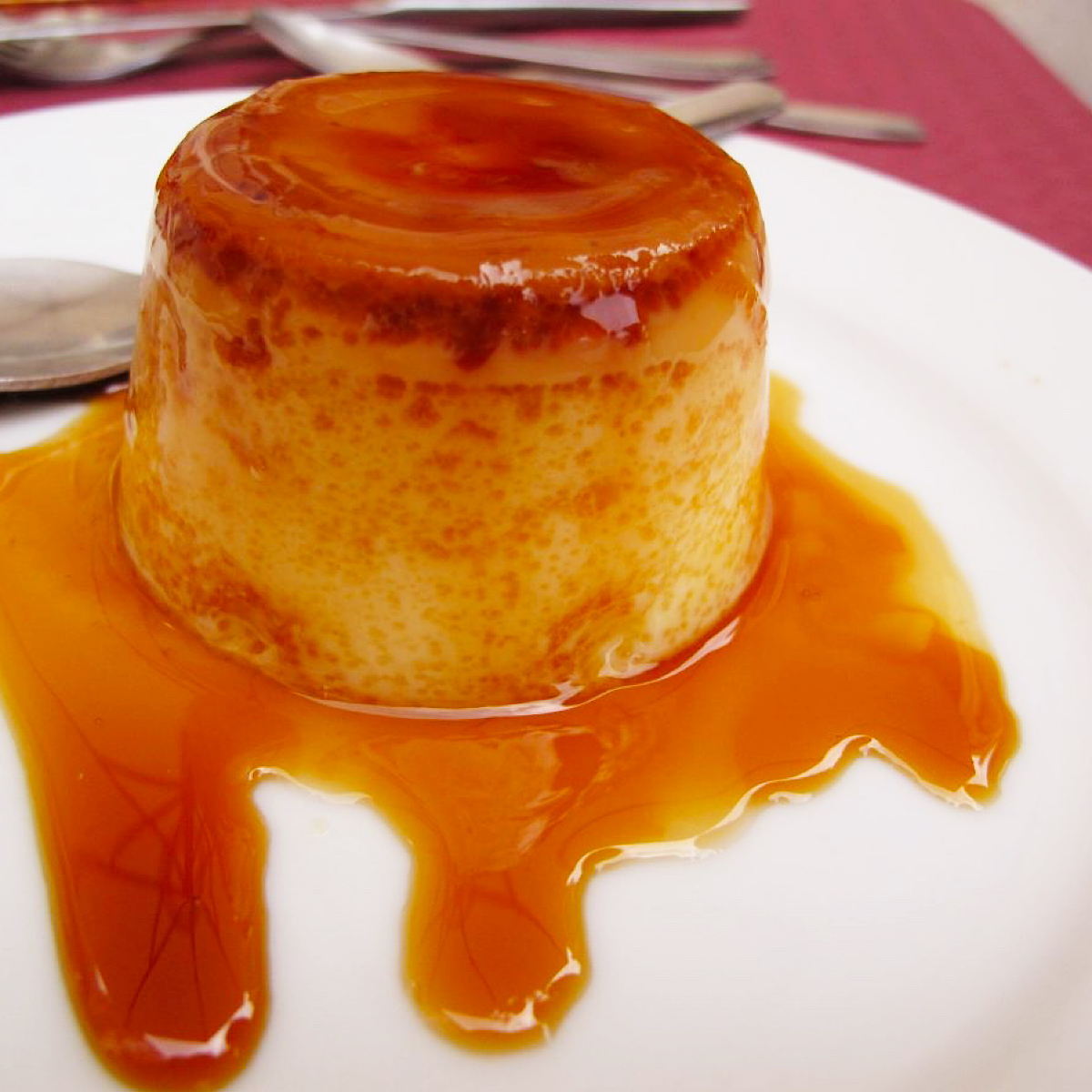 Caramel flan on a white plate from a Spanish restaurant.