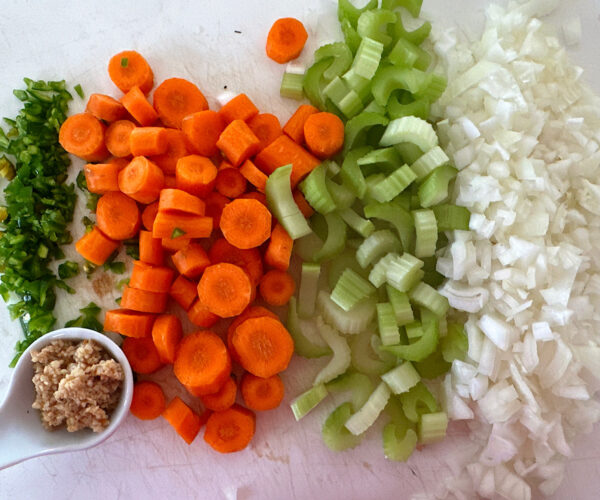 Chopped chile peppers, carrots, celery and onions ready to caramelize for Mexican fish soup.