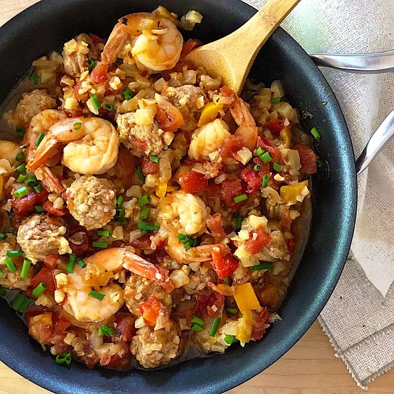 low carb jambalaya in a skillet with a wooden spoon.