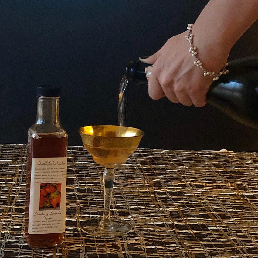 Adding strawberry lavender syrup to champagne for craft cocktail