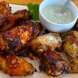 Plate of harissa baked wings and smoked wings with parmesan topping