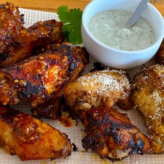 Plate of harissa baked wings and smoked wings with parmesan topping