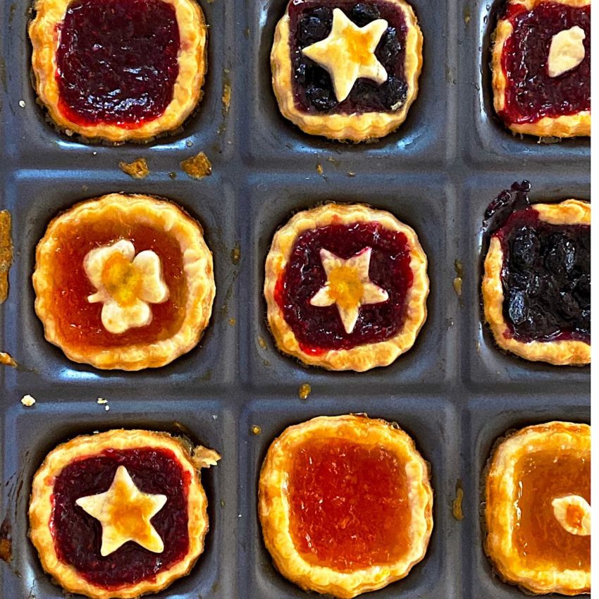 9 jam tarts in a baking tin made with pie dough and great jam