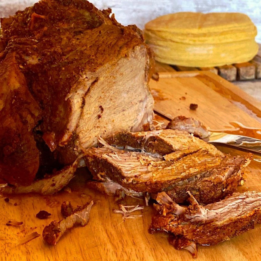 Sliced cochinita pibil with corn tortillas