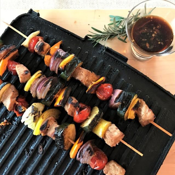 Pork veggie kebabs on an indoor grill with a Thai inspired  dipping sauce on the side.