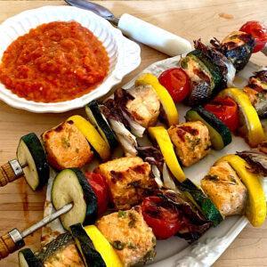 Salmon vegetable kebabs with a side dish of ajvar, a red bell pepper spread or sauce from the Balkans.