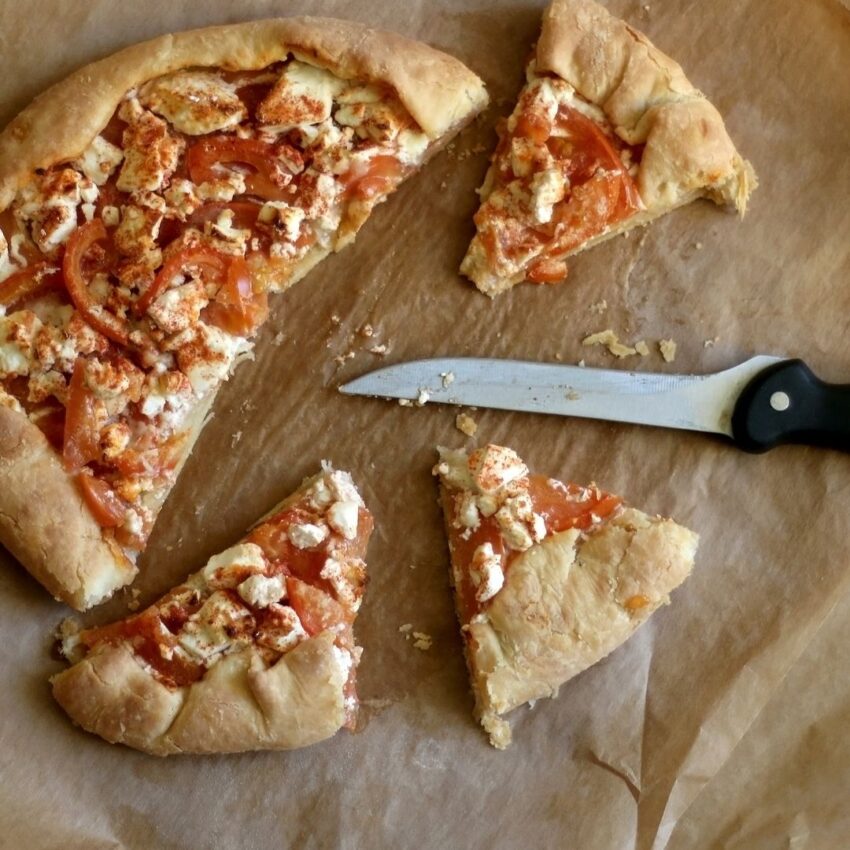 Tomato crostata or galette with 3 slices cut out.