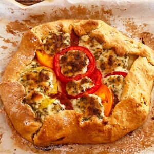 Freeform tomato crostata with heirloom tomatoes, cheese and herbs.