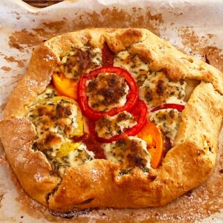 Freeform tomato crostata with heirloom tomatoes, cheese and herbs.