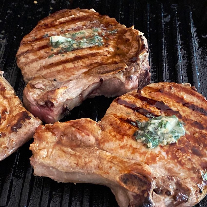 Pork chops with frozen sage butter melting on top